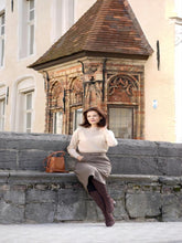 A lady wears a woollen skirt.